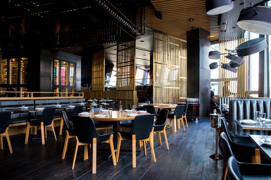 A low-lit restaurant interior with brass screens, dark timber floors and banquette seating